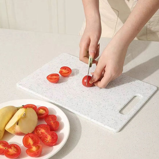 planche-a-decouper-personne-qui-coupe-une-tomate-cerise