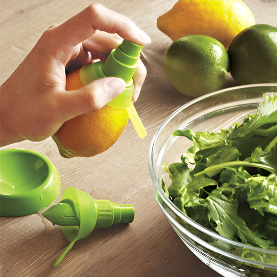 presse-agrume-personne-qui-vaporise-du-jus-de-citron-sur-la-salade