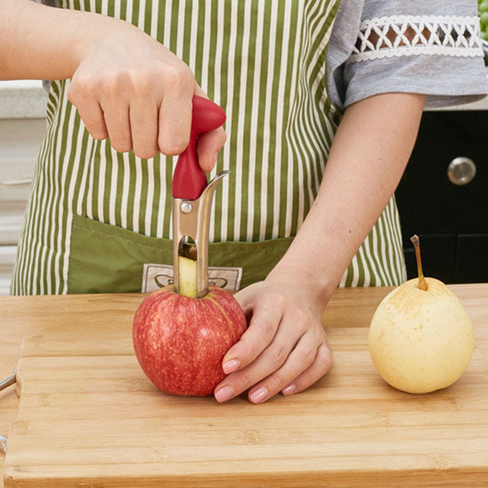 coupe-legumes-personne-qui-enleve-le-noyau-d-une-pomme-sur-une-planche-a-decouper