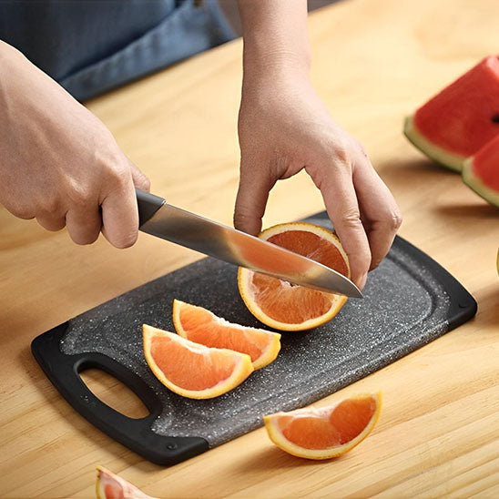 planche-a-decouper-coupe-orange-sur-comptoir