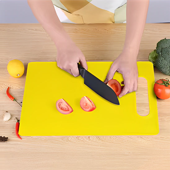 planche-a-decouper-jaune-avec-personne-qui-coupe-une-tomate-sur-un-comptoir