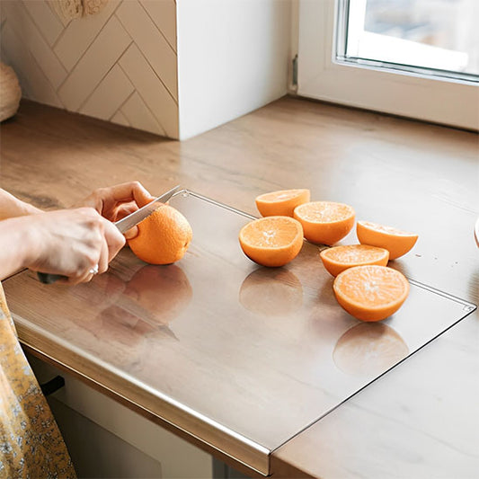 planche-a-decouper-personne-qui-coupe-une-orange-sur-un-comptoir