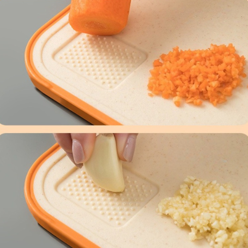 planche-a-decouper-personne-qui-rape-de-l-ail-et-une-carotte