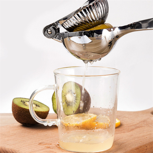 presse-agrume-personne-qui-extrait-du-jus-de-citron-dans-un-verre