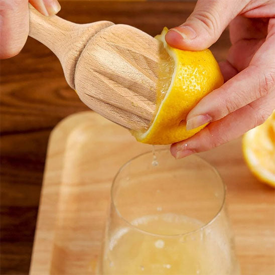 presse-agrume-personne-qui-extrait-le-jus-du-citron-dans-un-verre