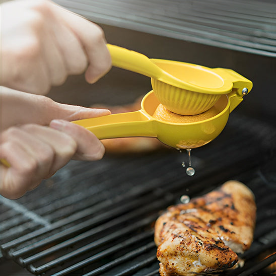 presse-agrume-personne-qui-presse-un-citron-sur-le-barbecue