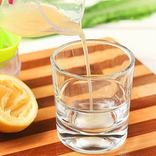 presse-agrume-personne-qui-verse-le-jus-de-citron-dans-un-verre