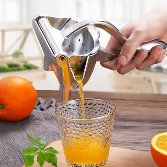 presse-agrume-personne-qui-verse-le-resultat-d-une-orange-dans-un-verre-sur-une-planche-a-decouper