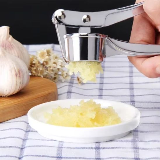 presse-ail-personne-qui-broye-de-l-ail-dans-une-assiette