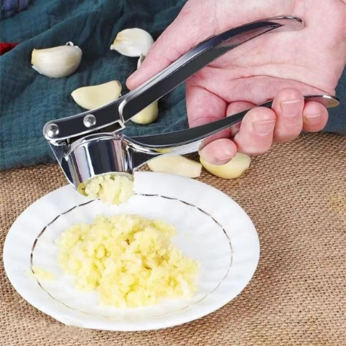 presse-ail-personne-qui-ecrase-de-l-ail-dans-une-assiette