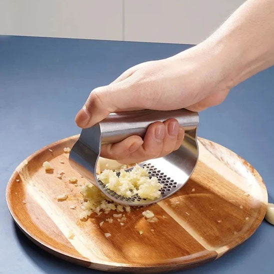 presse-ail-personne-qui-hache-de-l-ail-dans-une-assiette