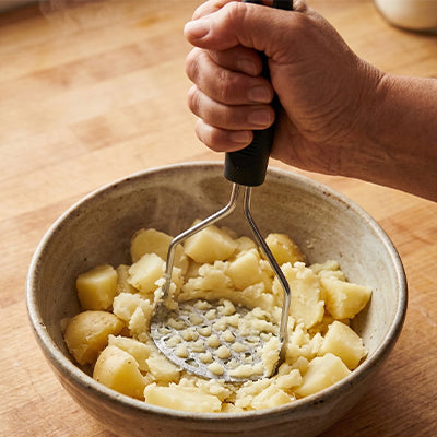 presse-puree-personne-qui-ecrase-dans-pomme-de-terre-dans-un-bol