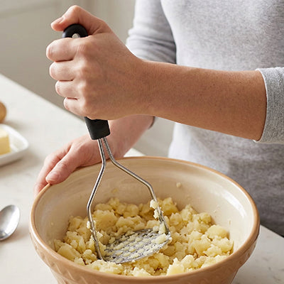 presse-puree-personne-qui-ecrase-dans-pomme-de-terre-dans-un-bol