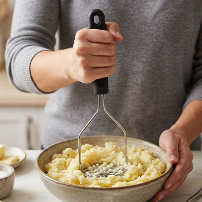 presse-puree-personne-qui-ecrase-dans-pomme-de-terre-dans-un-bol
