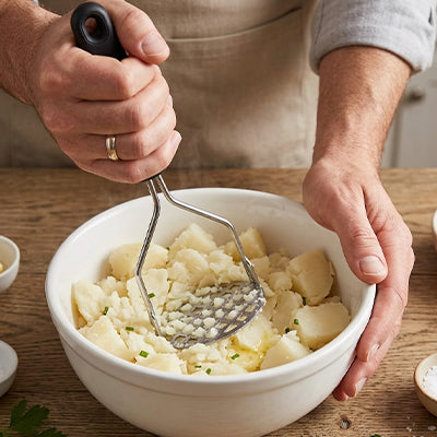 presse-puree-personne-qui-ecrase-dans-pomme-de-terre-dans-un-bol