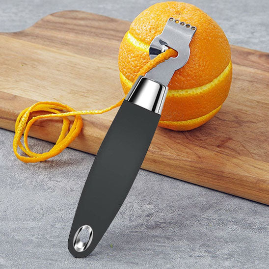 zesteur-personne-qui-a-zester-un-orange-sur-planche-a-decouper